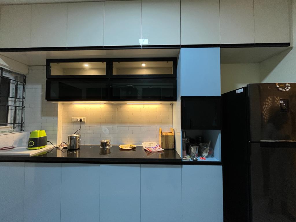 Rohan's Flat, Bangalore — Powder-blue glossy modular kitchen with black granite counter and backlit shelving