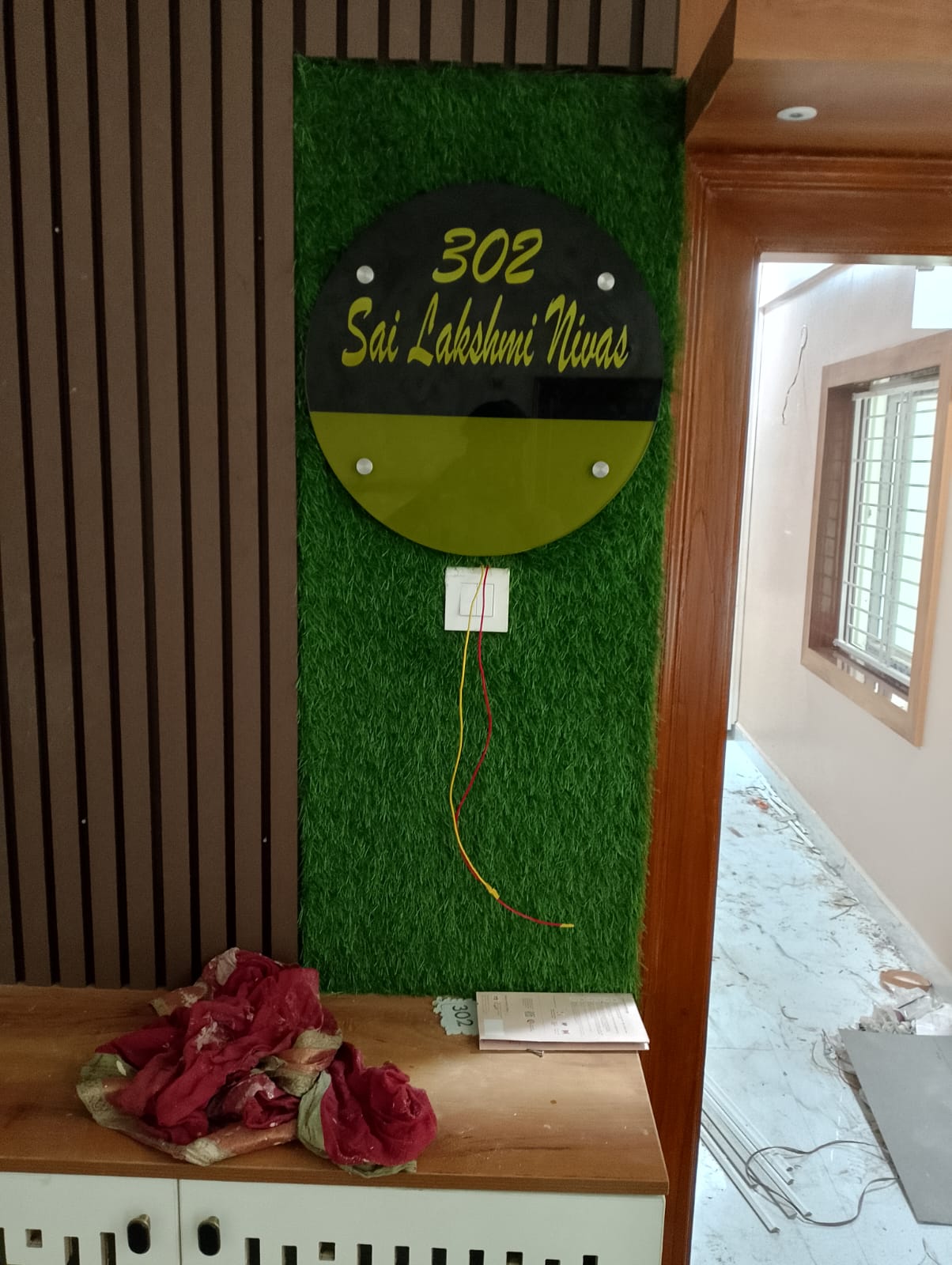 Manibhushan's House, Hyderabad — Nameplate feature wall in fluted wood with turf panel