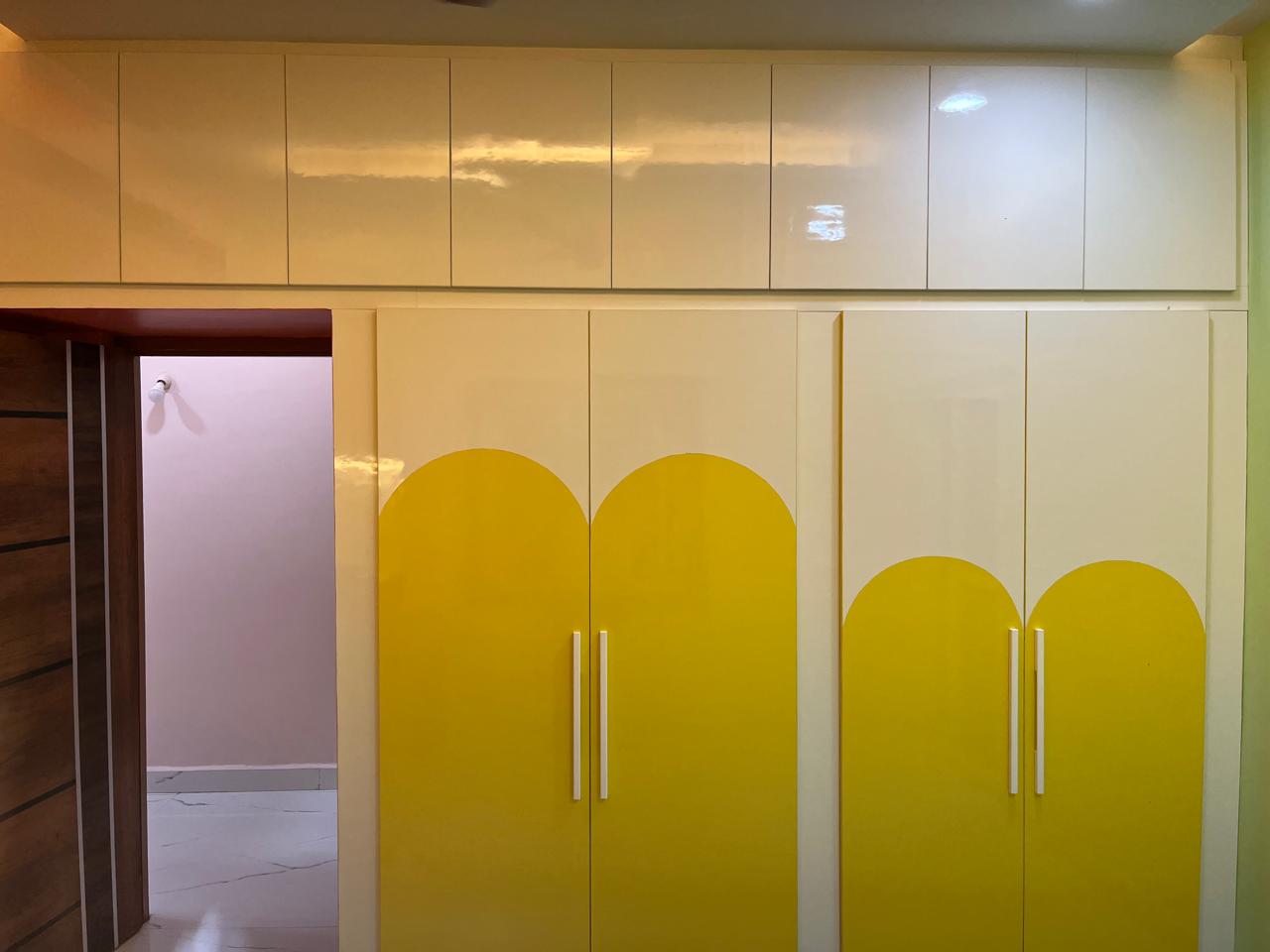 Manibhushan's House, Hyderabad — Arched-front wardrobe in ivory and lemon laminate